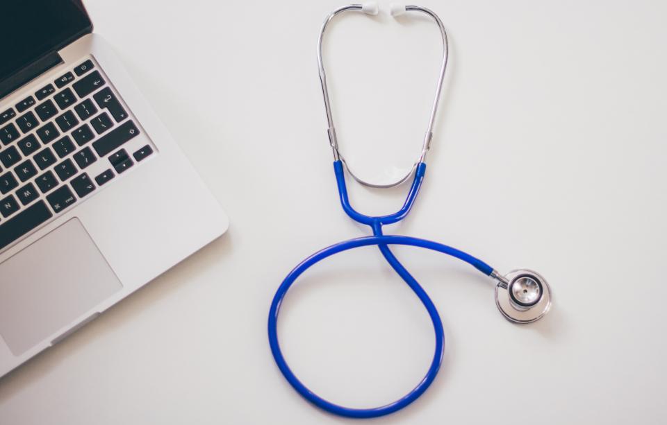 A stethoscope beside a laptop